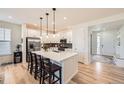 Modern kitchen with quartz countertops, pendant lighting, stainless steel appliances and wood floors at 515 176Th Ave, Broomfield, CO 80023