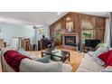 Cozy living room featuring a fireplace, wood paneling, and hardwood floors at 16724 E Hialeah Ave, Centennial, CO 80015
