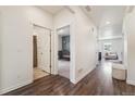 Bright hallway with wood floors that connects to a well-lit living area and a bedroom at 2226 Monte Vista St, Fort Lupton, CO 80621