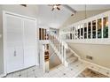 Bright foyer featuring white tile floors, closet, a staircase with white railings, and a view to the living room at 5050 W 102 Ave, Westminster, CO 80031