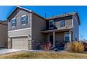 Attractive two-story home featuring stone accents, an attached garage, and a covered front porch at 579 Jewel St, Brighton, CO 80603