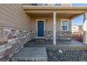 Inviting front porch with stone accents leading to a blue front door and house number at 579 Jewel St, Brighton, CO 80603