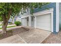 Inviting townhouse showcasing a clean white garage door, well-manicured landscaping, and a welcoming entrance at 1699 S Trenton St # 174, Denver, CO 80231