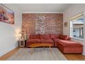 Cozy living room featuring an exposed brick wall, plush sectional sofa, and bright natural light at 421 Elati St, Denver, CO 80204
