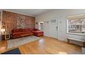 Comfortable living room featuring an exposed brick wall, hardwood floors, and natural light at 421 Elati St, Denver, CO 80204