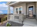 Charming front porch with stone accents, a white railing and ample space for seating and curb appeal at 3128 Bivouac Pt, Castle Rock, CO 80108