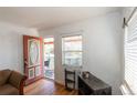 Cozy entryway featuring hardwood floors, a window, and a view of the covered front porch at 4849 Lincoln St, Denver, CO 80216