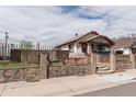 View of the property's exterior featuring manicured landscaping, secure fencing and stone accents at 4849 Lincoln St, Denver, CO 80216