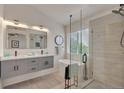 Spa-like bathroom features dual vanity, soaking tub, and glass-enclosed shower with sleek modern design at 9884 Sydney Ln, Highlands Ranch, CO 80130