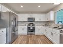 Modern kitchen features stainless steel appliances, white cabinets, granite countertops, and a stylish backsplash at 9884 Sydney Ln, Highlands Ranch, CO 80130