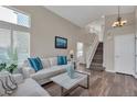 Bright living room with wood floors, a staircase, high ceilings, and comfortable seating at 9884 Sydney Ln, Highlands Ranch, CO 80130