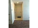 Neutral hallway leading to front door with neutral carpet at 2355 E Geddes Ave # G24, Centennial, CO 80122