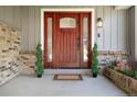 Inviting front entry features a beautifully crafted wood door with decorative glass sidelights and brick accents at 6474 W Canyon Ave, Littleton, CO 80128