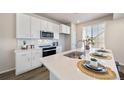 Modern kitchen with white cabinets, quartz countertops, and stainless steel appliances at 22042 E 38Th Pl, Aurora, CO 80019