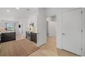 Open-concept living area with hardwood floors, modern kitchen, and doorway to bathroom at 2530 Lawrence St # Ra301, Denver, CO 80205