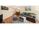 Open-concept living area with wood floors, dining area, and a comfortable gray sofa at 2 Acoma St # 11, Denver, CO 80223