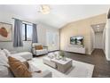 Bright living room features shiplap accent wall, modern furniture, and access to the outside through double doors at 8367 S Reed St # A3, Littleton, CO 80128