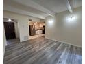 Open living room with plank floors, open to kitchen, and bright lighting at 9995 E Harvard Ave # 261, Denver, CO 80231