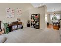 Bright living room with bookshelves and view into kitchen and dining area at 1234 Riddlewood Ln, Highlands Ranch, CO 80129