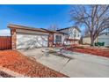 Brick and light-colored siding home with a two-car garage and mature tree at 1912 S Truckee St, Aurora, CO 80013