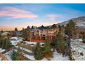 Beautiful home with a deck, large windows, and landscaping nestled against a mountain backdrop at 15895 W Bayaud Dr, Golden, CO 80401