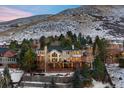 Expansive home featuring multiple decks, large windows, and stunning mountain views in a tranquil, snowy setting at 15895 W Bayaud Dr, Golden, CO 80401