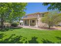 Back porch overlooks a green lawn with trees and a view to nature at 3480 Spruce Dell Ct, Castle Rock, CO 80109