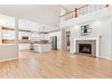 Open-concept space featuring a fireplace, hardwood floors, and a second-floor balcony at 3480 Spruce Dell Ct, Castle Rock, CO 80109