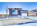 Modern home with stone and siding exterior and two-car garage at 8871 S Quemoy St, Aurora, CO 80016