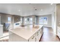 Modern kitchen with island, white cabinets, and stainless steel appliances at 8871 S Quemoy St, Aurora, CO 80016