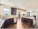Open concept kitchen with a granite island, stainless steel appliances, dark wood cabinets, and hardwood floors at 3216 Yale Dr, Broomfield, CO 80023