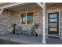 Inviting front porch featuring stone accents, exterior lighting, and a cozy seating area, enhancing the home's curb appeal at 12205 Race St, Northglenn, CO 80241