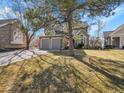 Attractive two-story home boasts a stone and siding exterior, complemented by a well-kept lawn and mature trees at 8312 S Peninsula Dr, Littleton, CO 80120