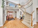 Grand foyer with a curved staircase, hardwood floors, and a two-story ceiling at 8312 S Peninsula Dr, Littleton, CO 80120