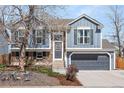 Charming two-story home with a gray garage door, brick accents, and a well-manicured front yard at 11225 W 102Nd Pl, Westminster, CO 80021