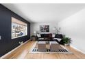 Living room with hardwood floors, sectional sofa, and large window at 6524 Teller St, Arvada, CO 80003