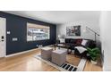 Living room with hardwood floors, sectional sofa, and large window at 6524 Teller St, Arvada, CO 80003