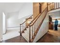 Elegant staircase showcasing wood banisters and bright, natural light from a vaulted ceiling at 4855 S Joplin St, Aurora, CO 80015