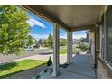 Covered front porch with view of landscaped yard and quiet street at 4037 S Odessa Cir, Aurora, CO 80013