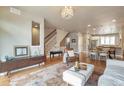 Spacious living area with hardwood floors, access to stairs and open concept kitchen and dining area at 15592 W Wesley Ave, Lakewood, CO 80228