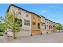 View of the townhome exteriors with attached garages and well maintained landscaping at 15592 W Wesley Ave, Lakewood, CO 80228