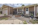 Inviting front porch and entrance with a cozy seating area, potted plants, and clear house number at 6267 S Albion Ct, Centennial, CO 80121