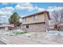 Two-story home with stone exterior and a spacious driveway at 4865 Scranton Ct, Denver, CO 80239