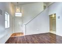 Bright living room with hardwood floors, a high ceiling, and a modern staircase at 1438 Stockton Dr, Erie, CO 80516