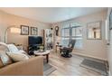 Inviting living room with neutral paint, wood flooring, and a large arched window at 1648 S Cole St # A2, Lakewood, CO 80228