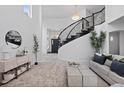 Bright open foyer featuring a winding staircase, high ceilings, and stylish decor at 5773 S Benton Way, Littleton, CO 80123