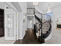 Elegant foyer showcasing a stunning curved staircase and dark wood floors at 5773 S Benton Way, Littleton, CO 80123