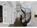 Grand foyer with a curved staircase, dark wood floors, and elegant chandelier lighting at 5773 S Benton Way, Littleton, CO 80123