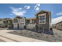 Beautiful home with gray stone and siding, complemented by a two-car garage and manicured landscaping at 651 Scrubjay Cir, Castle Rock, CO 80104