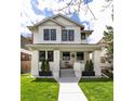 Charming two-story home with inviting front porch and manicured lawn on a sunny day at 619 S Gilpin St, Denver, CO 80209